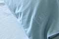 Lyseblåt pudebetræk med DAGGRY-logo.